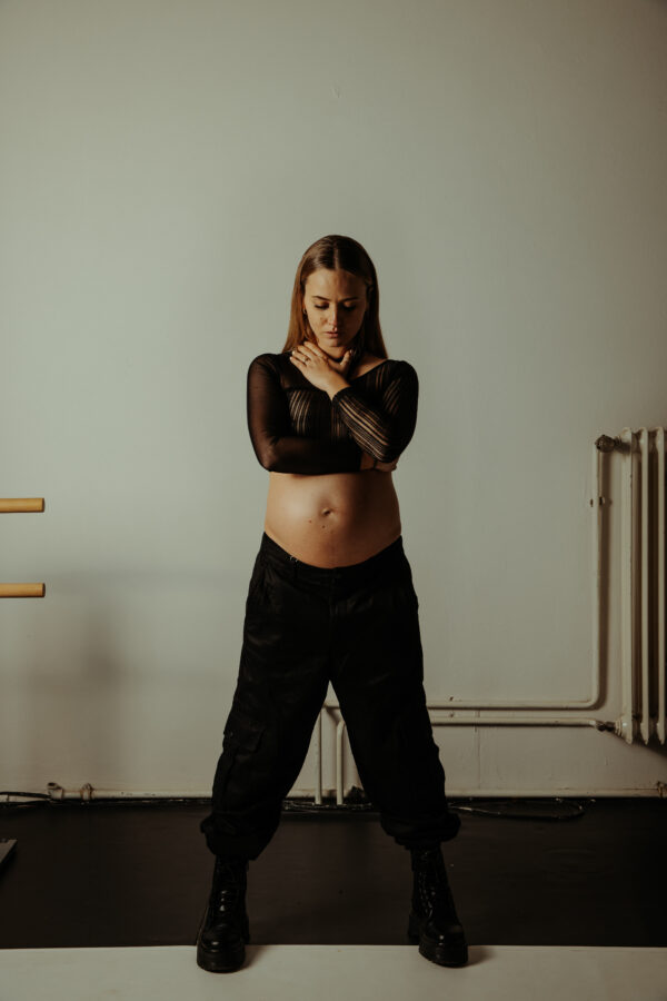 hier ist der maternity fotografie service zu sehen. Die schwangere Frau trägt schwarze kleidung und der Bauch ist frei.