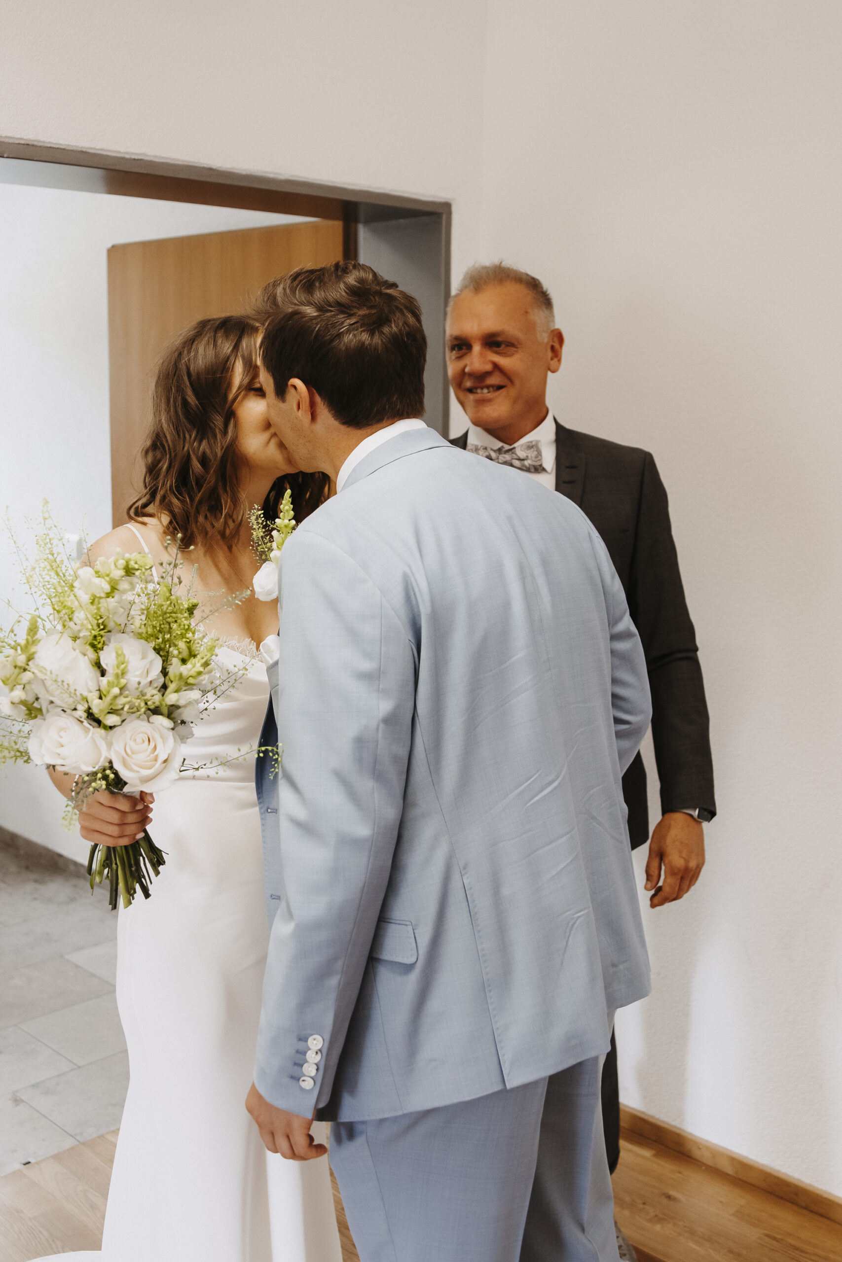 Braut und Bräutigam sehen sich das erste Mal und küssen sich vor dem Brautvater