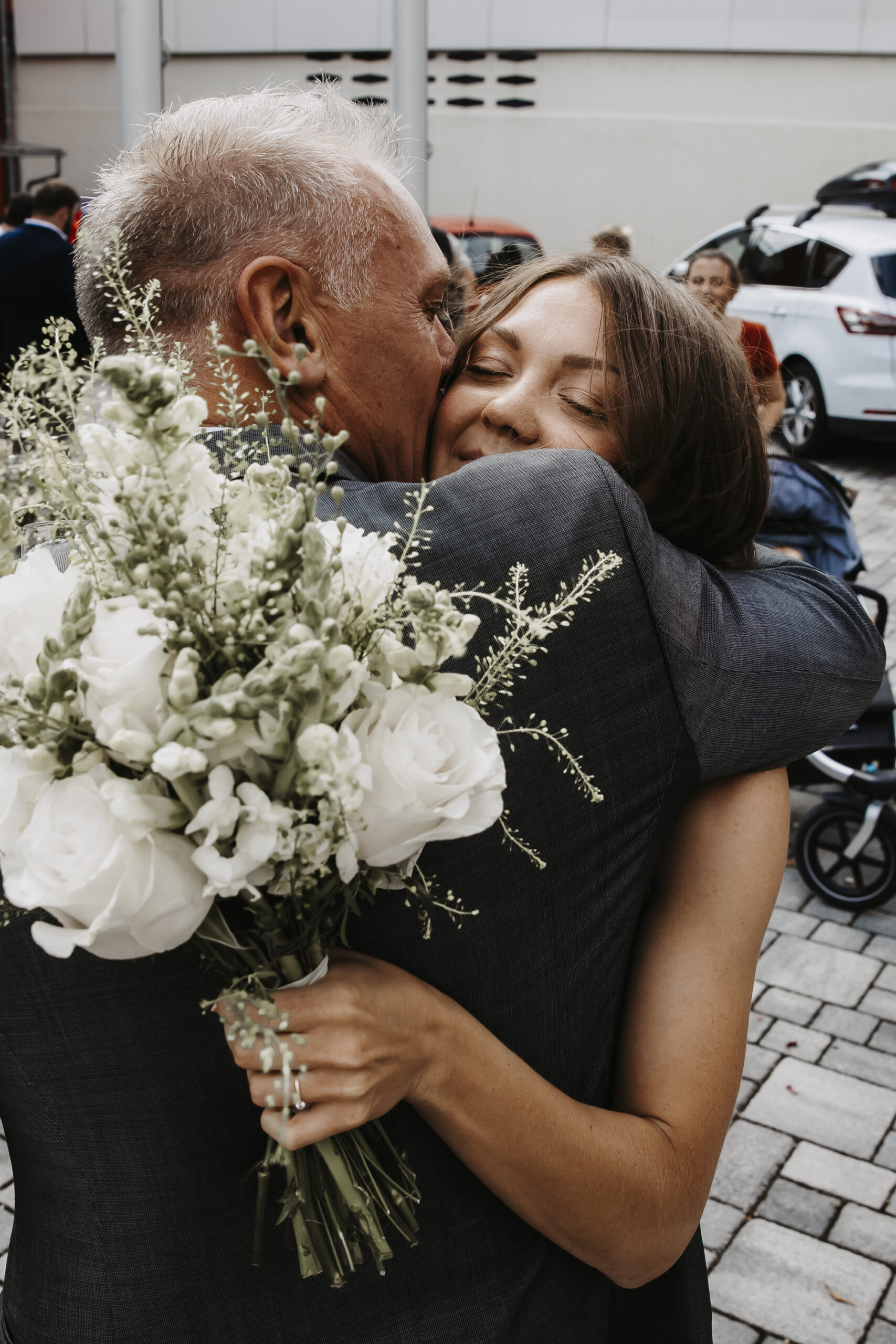 Brautvater umarmt Brauttochter und gratuliert ihr zur Eheschließung