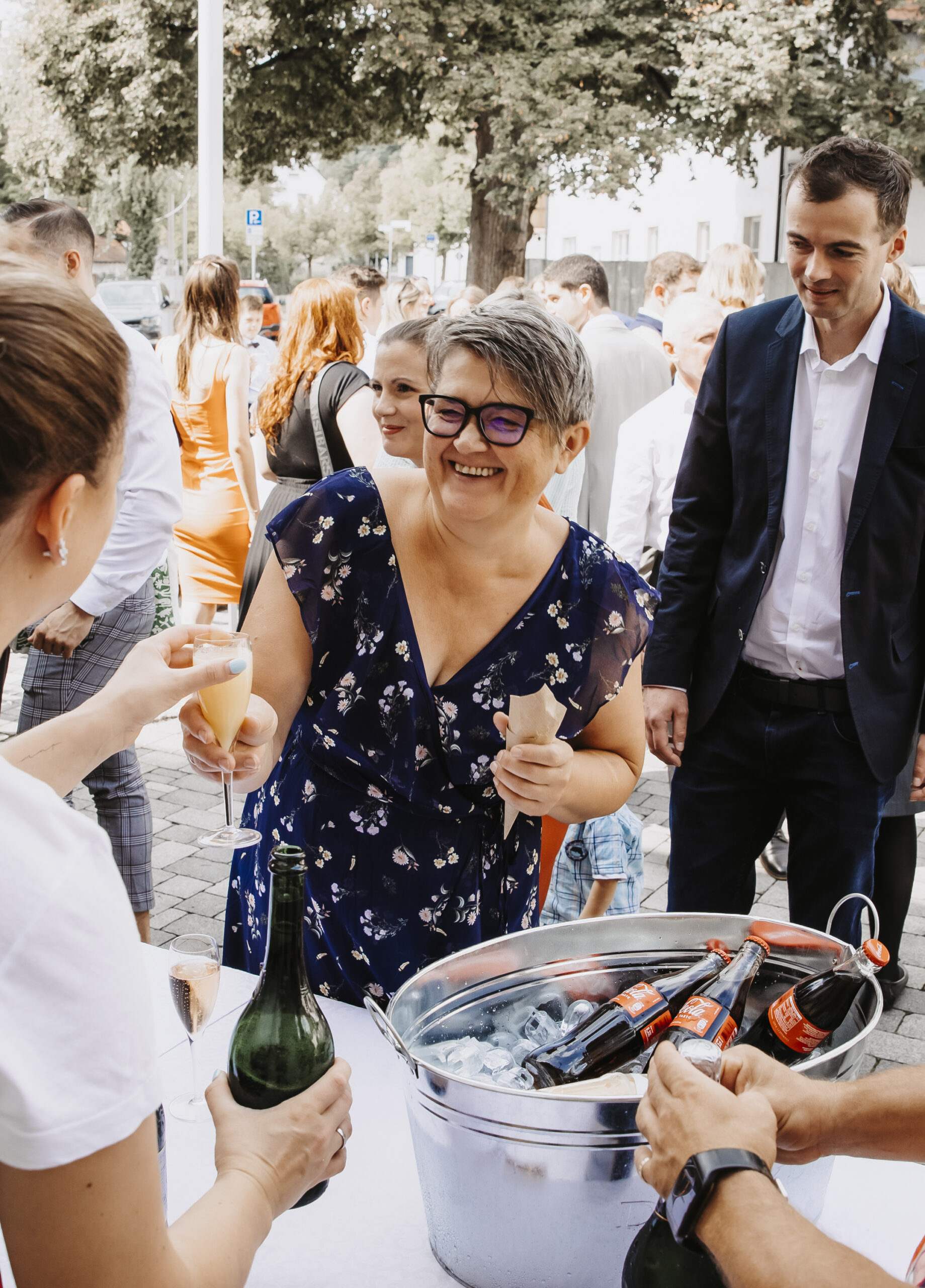 Glückliche Frau bekommt ein Sektglas während dem Sektempfang einer Hochzeit vor dem Rathaus in Munzingen