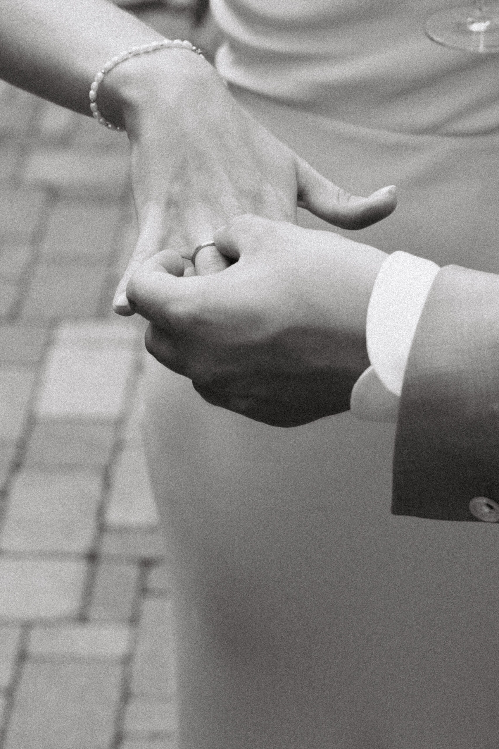 Ehepaar zeigt seinen Gästen die Ringe. Hände von Ehefrau und Ehemann zu sehen in schwarz weiß