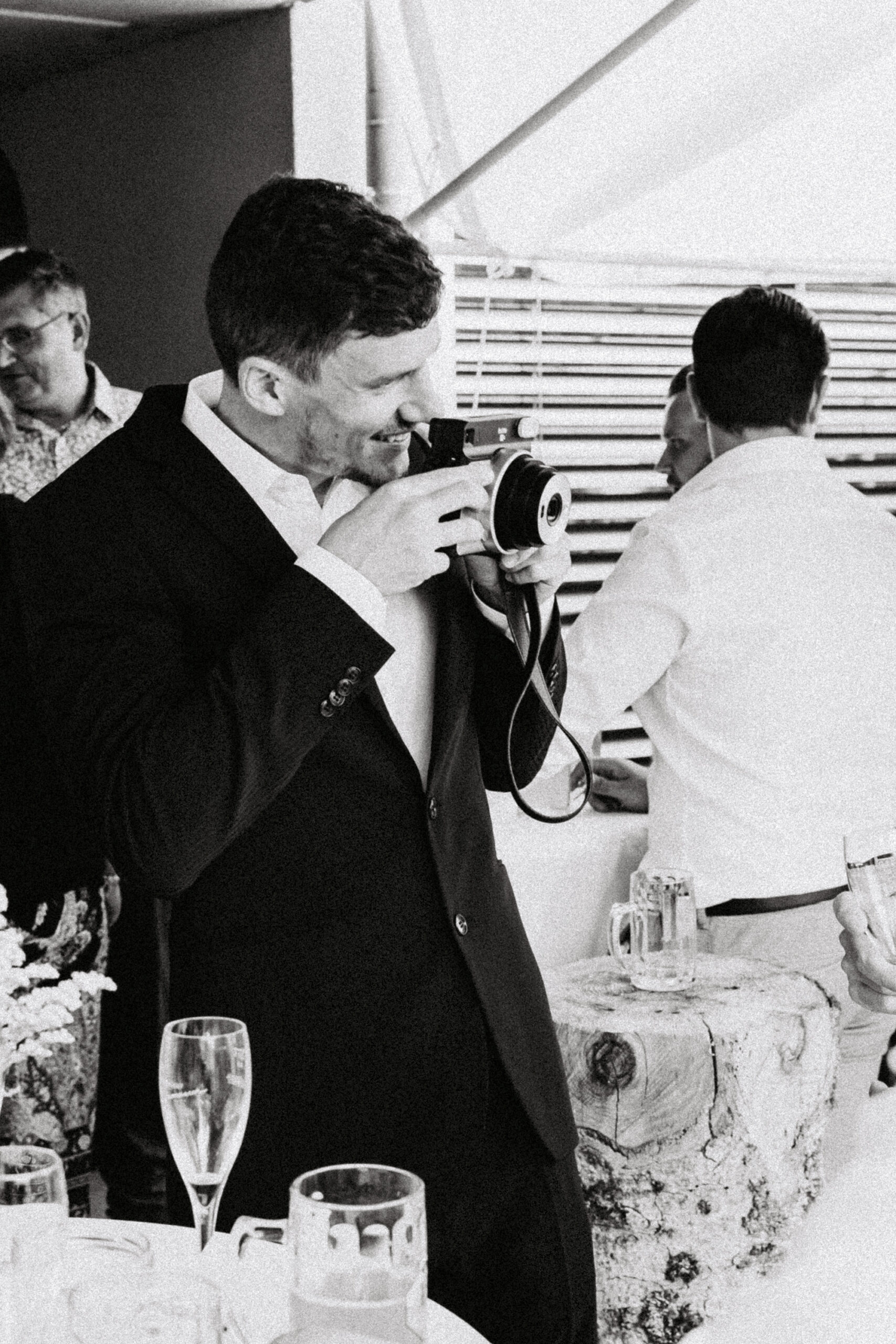Hochzeitgast fotofrafiert andere Gäste mit der Polaroidkamera