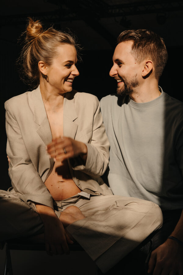 Ein verliebtes Paar schaut sich lachend an während einem Maternityshooting & Coupleshooting in Zürich. - Hochzeitsbilder Schweiz