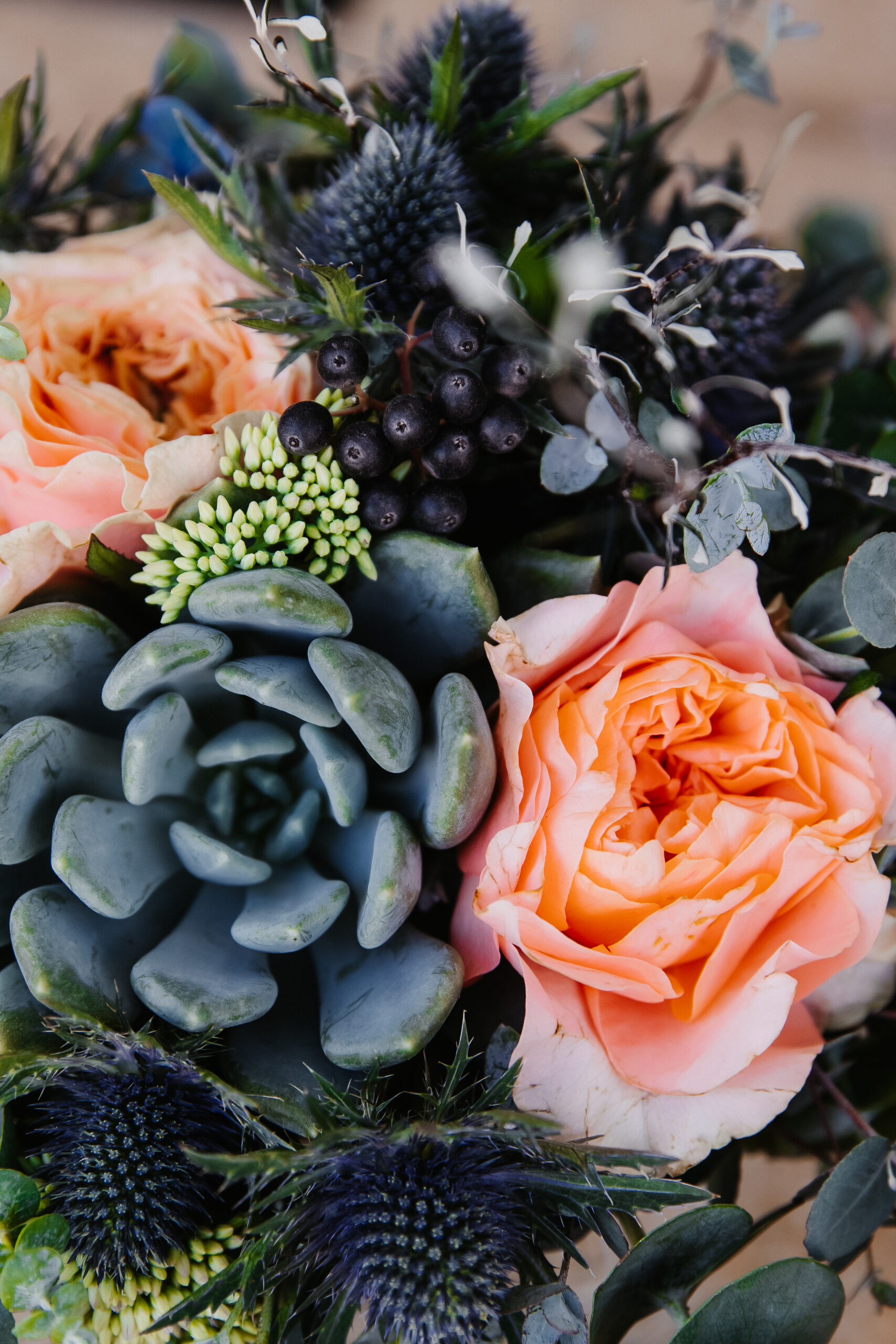 Blauer Brautstrauß mit Disteln, sukkulenten und pfirsichfarbenen Rosen