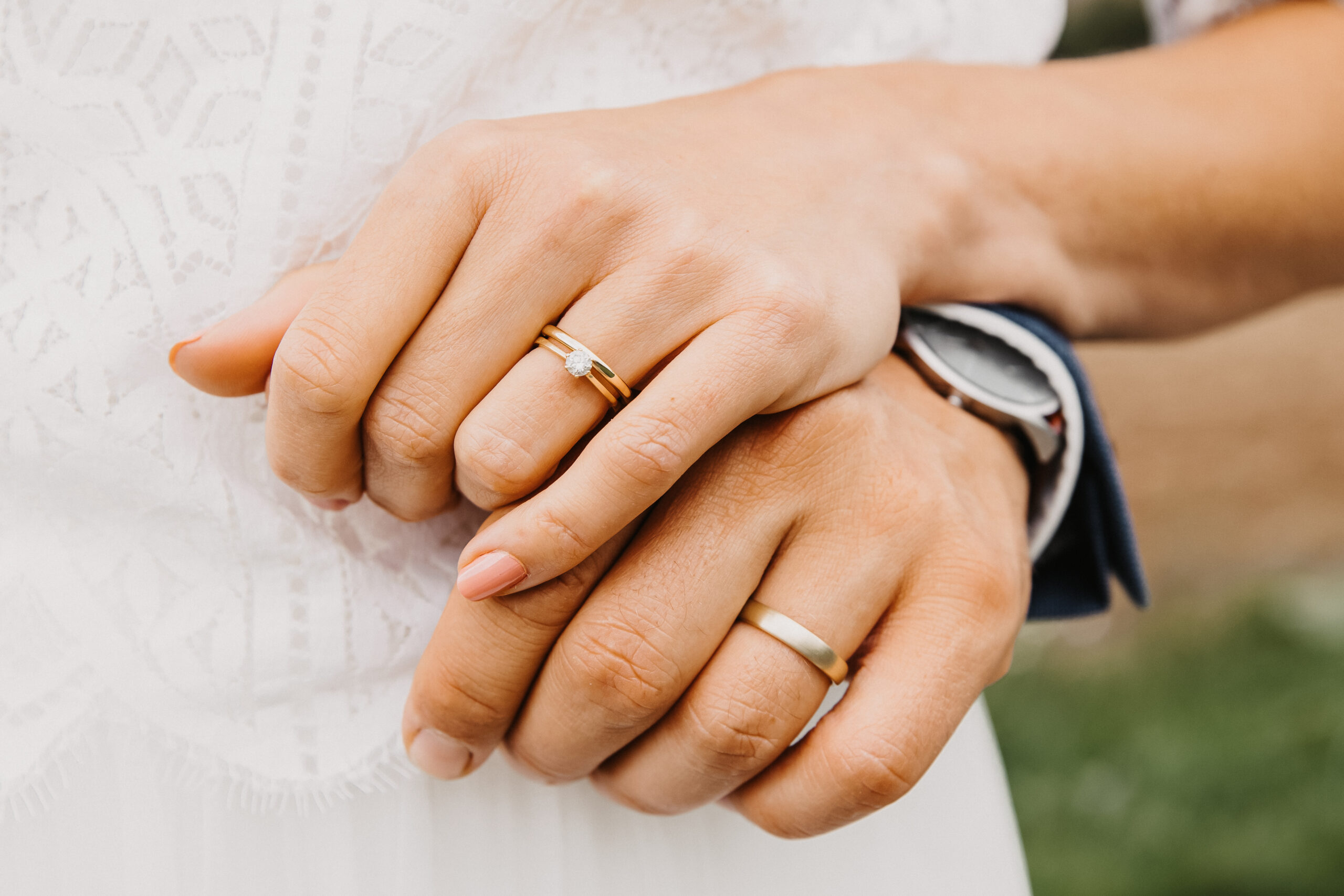 Detailaufnahme der Hände des Brautpaares mit den Eheringen und die schön gemachten Nägel der Braut sind auch zu sehen.