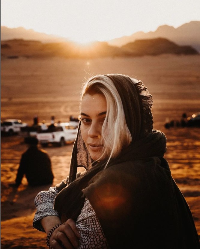 The Photgrapher Girl in the desert of Jordan during the sunset.