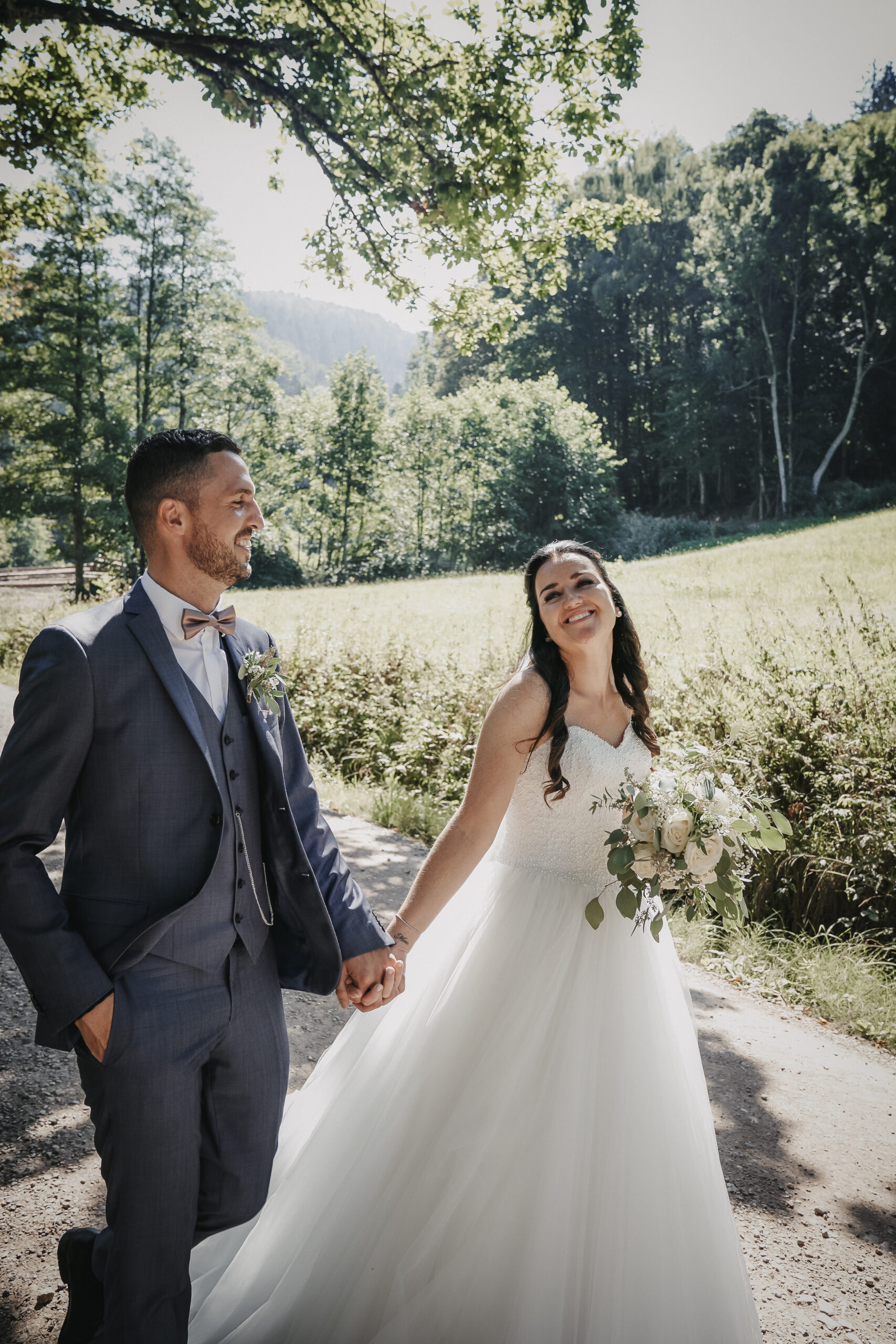 Brautpaar läuft Hand in Hand durch einen Weidenweg im Schwarzwald - Heiraten im Schwarzwald