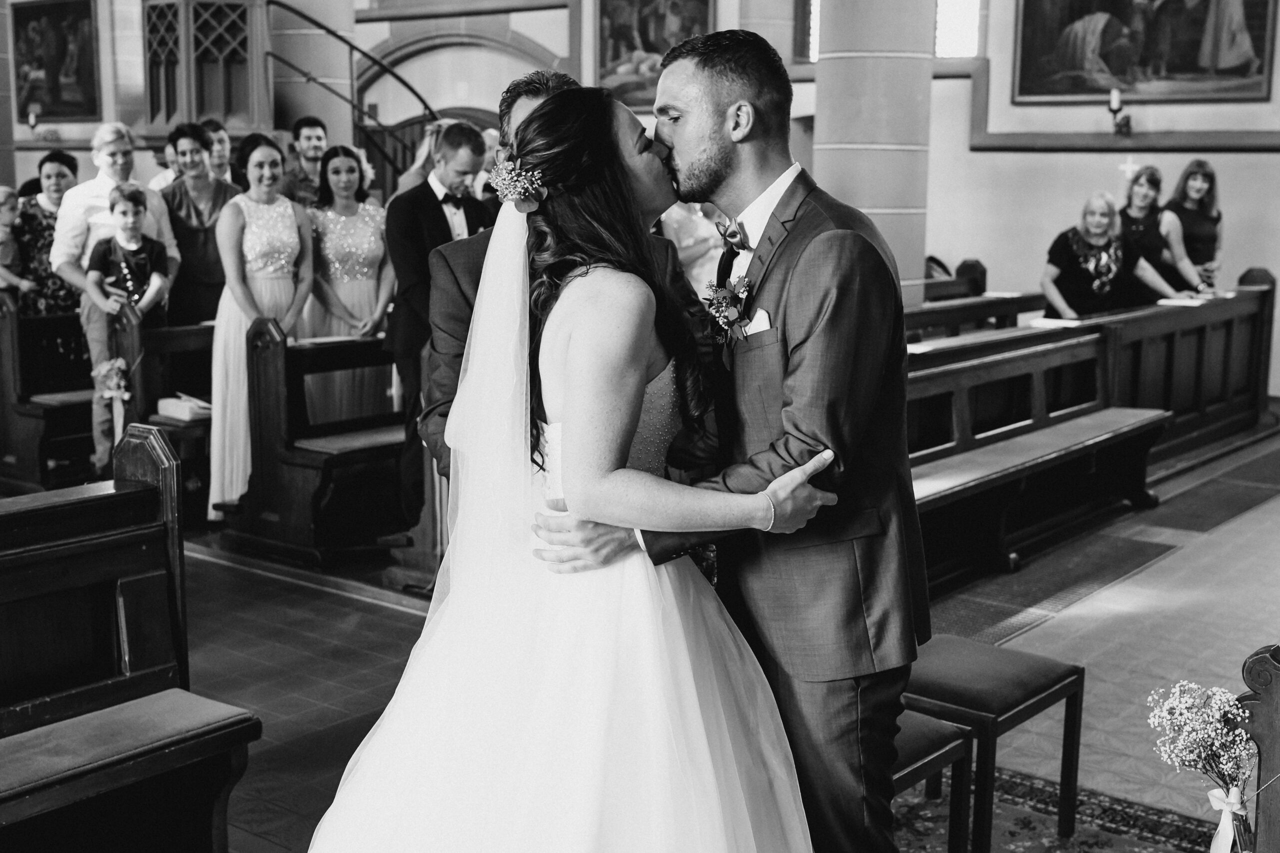 Das Brautpaar küsst sich in der Kirche nach dem der Brautvater die Braut zum Altar als Einlauf begleitet hat.