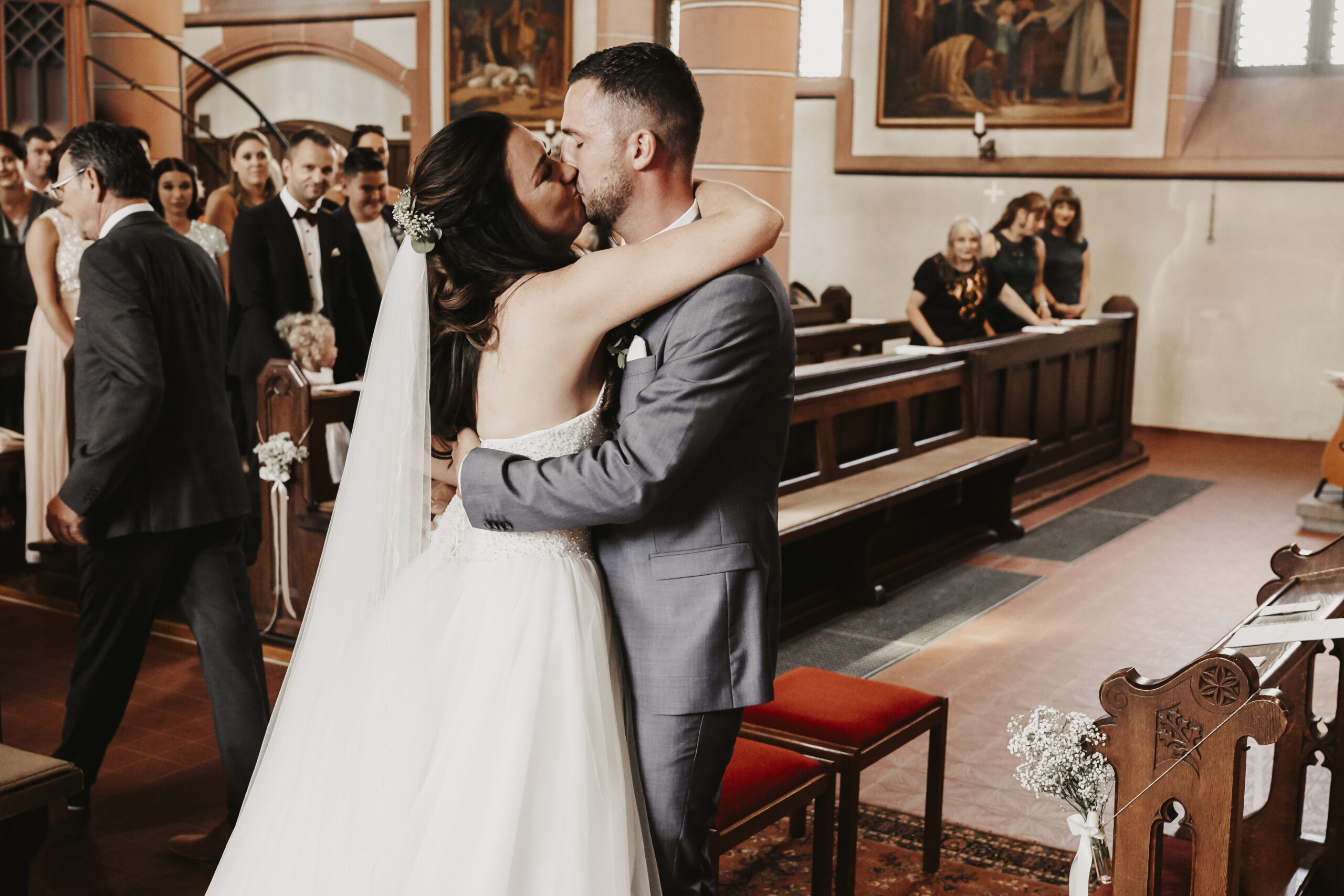 Das Brautpaar küsst sich in der Kirche nach dem der Brautvater die Braut zum Altar als Einlauf begleitet hat.