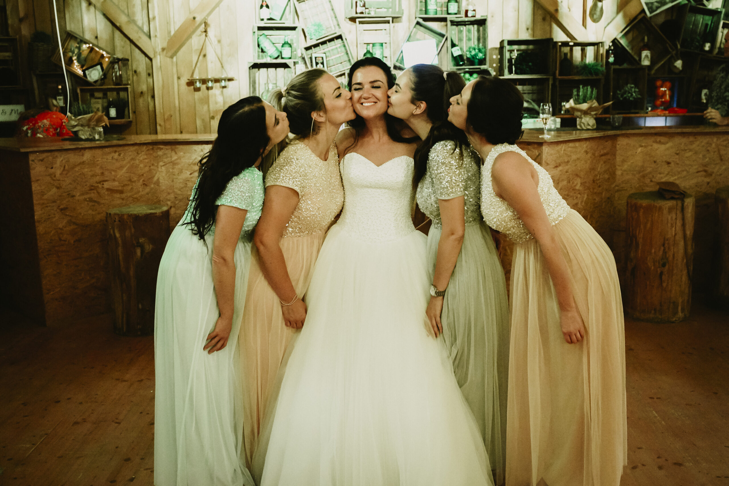 Die Brautjungfern geben in der Hochzeitslocation am Abend der Braut einen Kuss