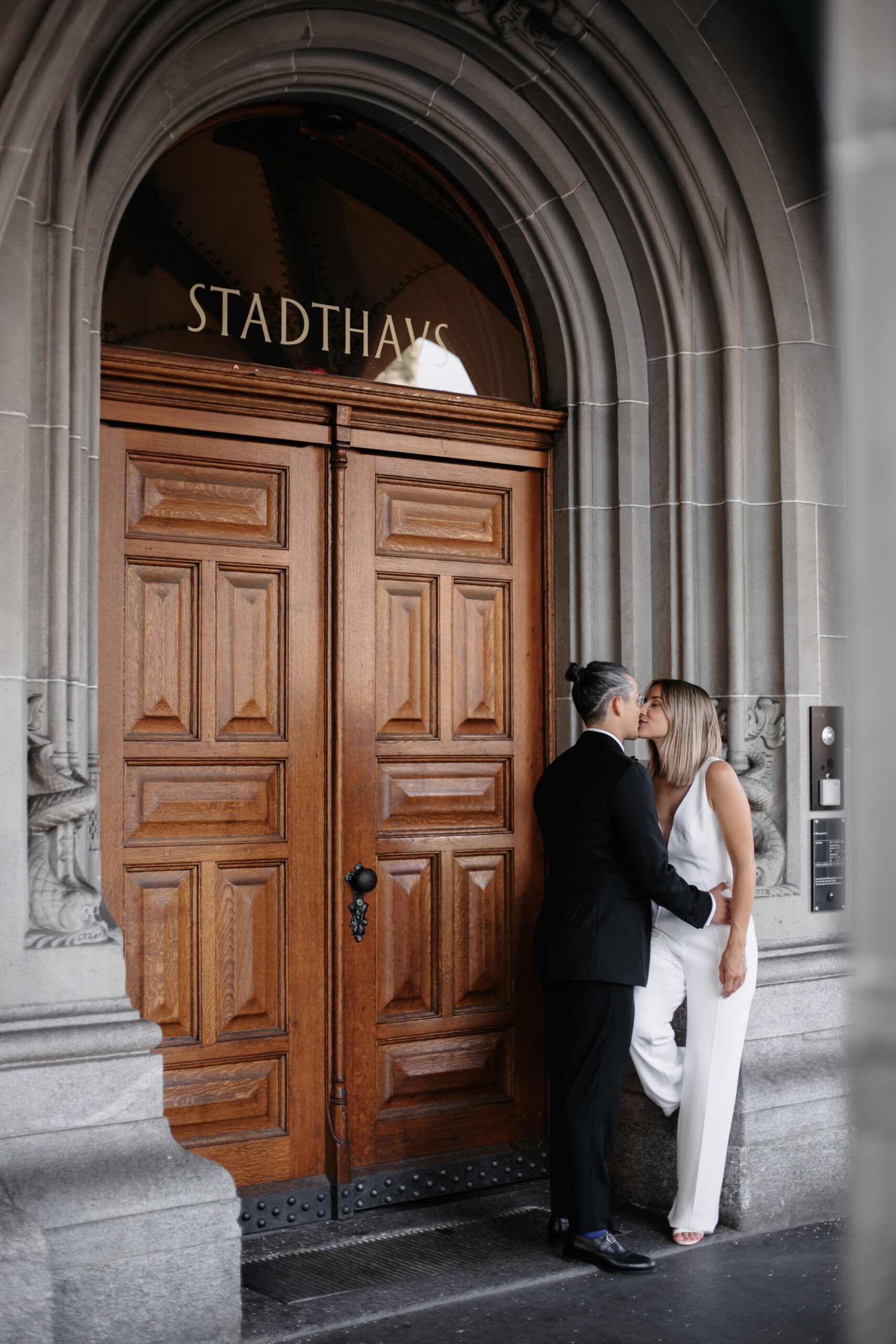 Das Brautpaar küsst sich vor dem Stadthaus Zürich kurz nach der Trauung